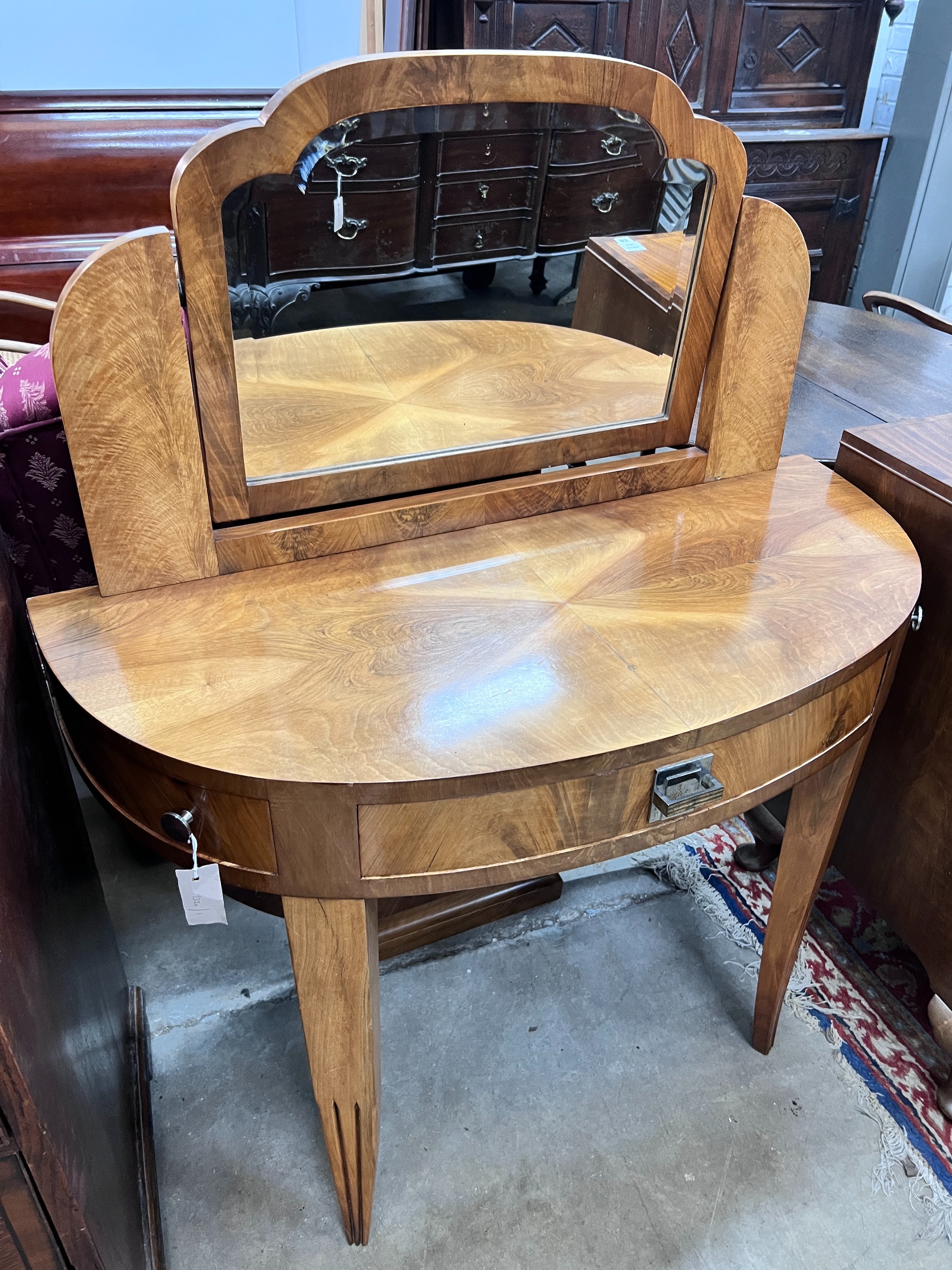 An Art Deco walnut D shaped dressing table, width 100cm, depth 45cm, height 122cm *Please note the sale commences at 9am.